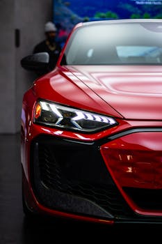 Close-up of a sleek red sports car in a Toronto showroom, showcasing elegant design and lighting.