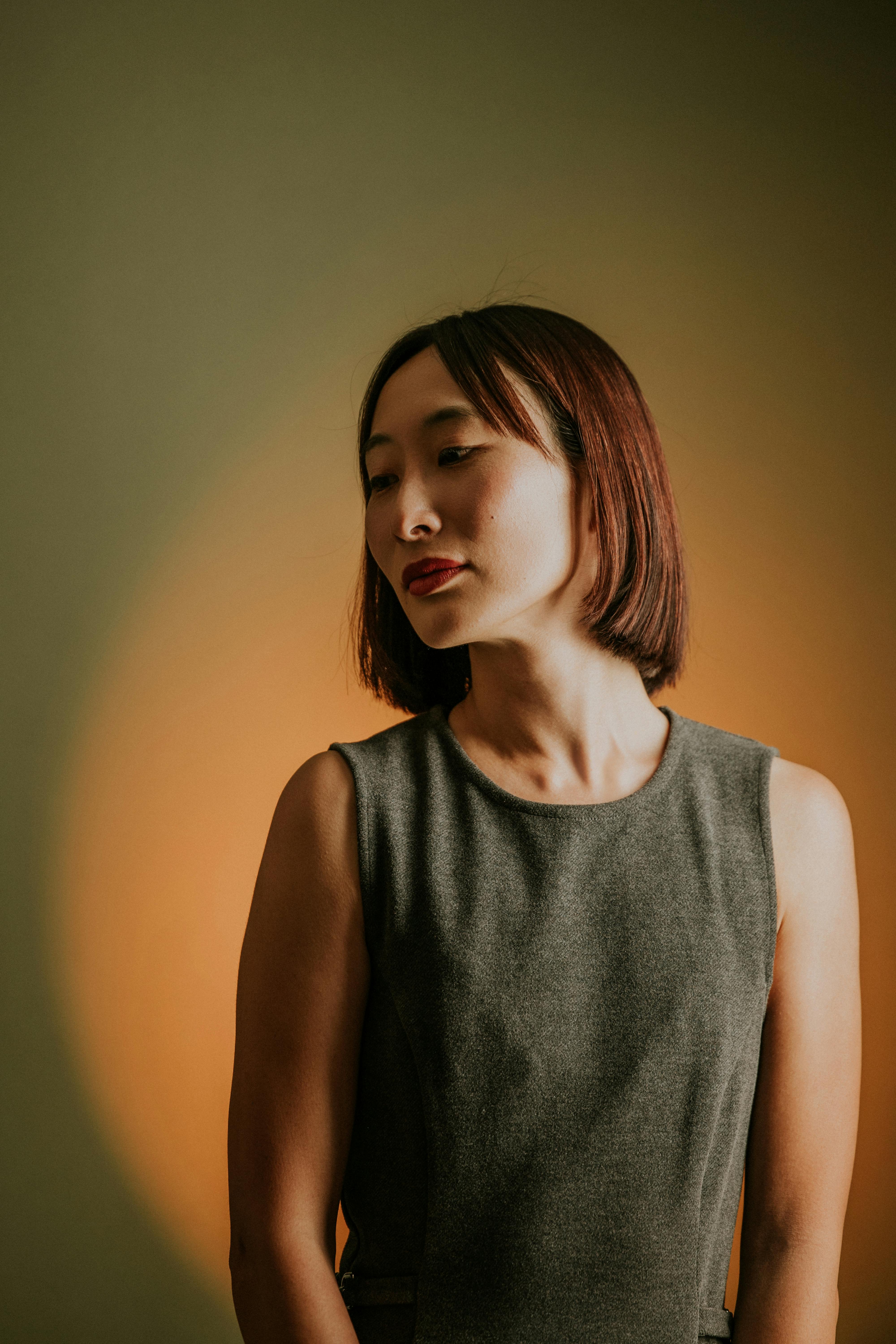 Stylish portrait of an adult woman in warm lighting, showcasing elegance and beauty.