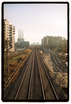 Railway tracks leading into urban sunset skyline. Perfect for travel and urbanization themes.