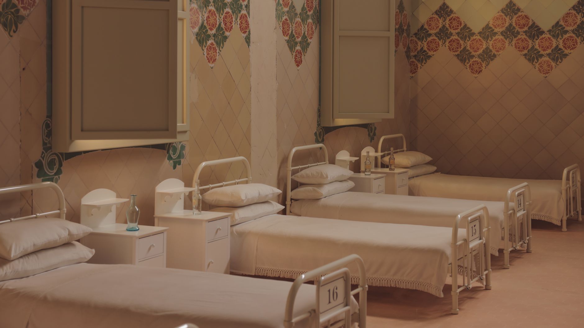 A serene and vintage hospital ward with empty beds in Barcelona.