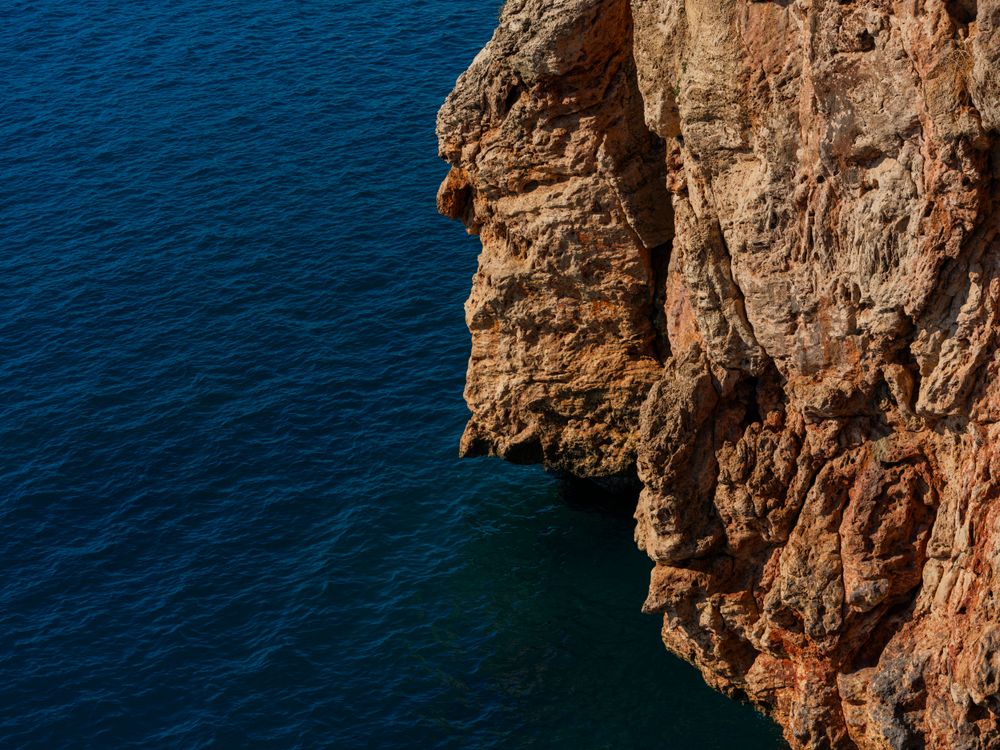 Deep Cliff With Rocks Majestic Coastal Cliff over Deep Blue Ocean · Free Stock Photo