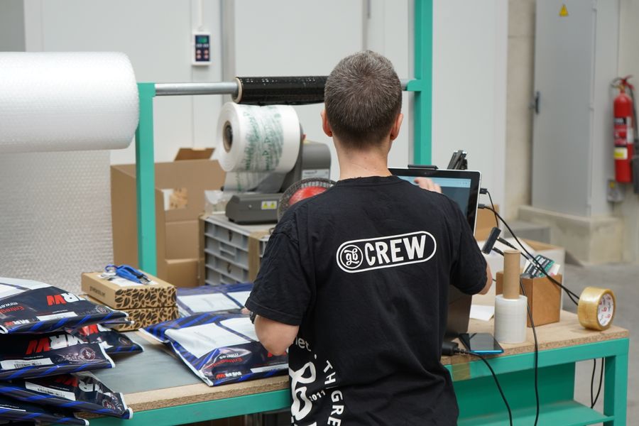 Warehouse worker using computer for inventory management at logistic center.