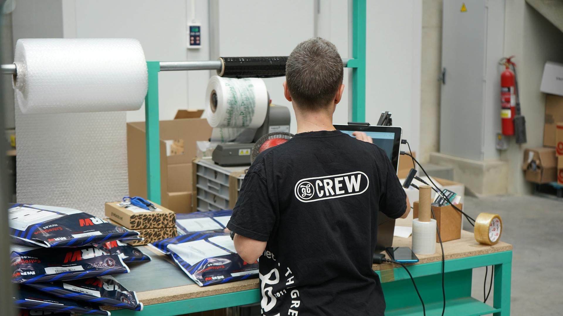 Warehouse worker using computer for inventory management at logistic center.