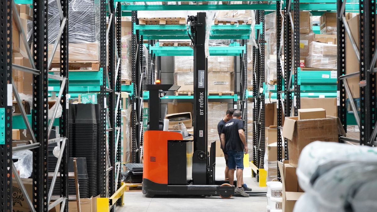 Workers and a forklift operating in a modern warehouse