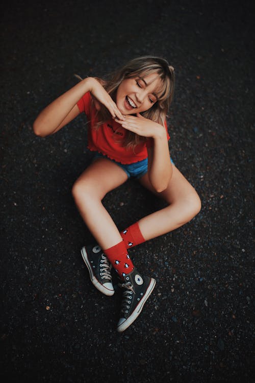 Free Photo of Smiling Woman Sitting on Ground Posing With Her Eyes Closed Stock Photo