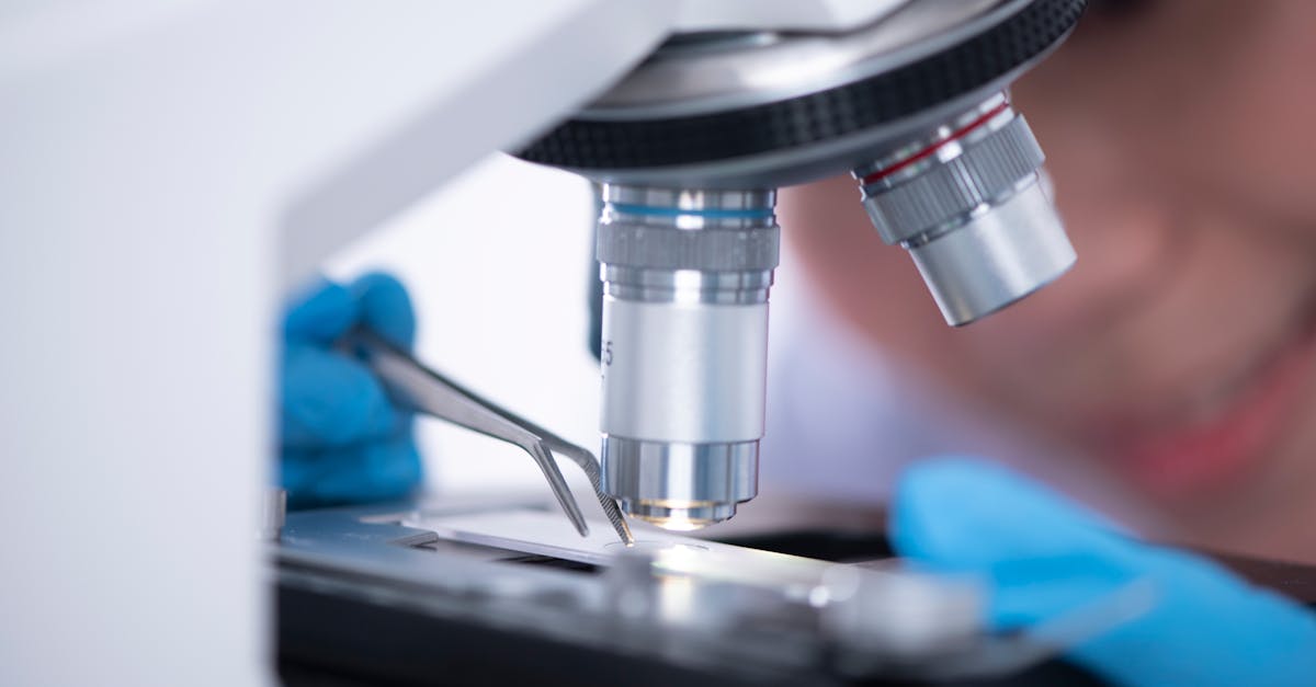 Unrecognizable scientist using microscope in lab