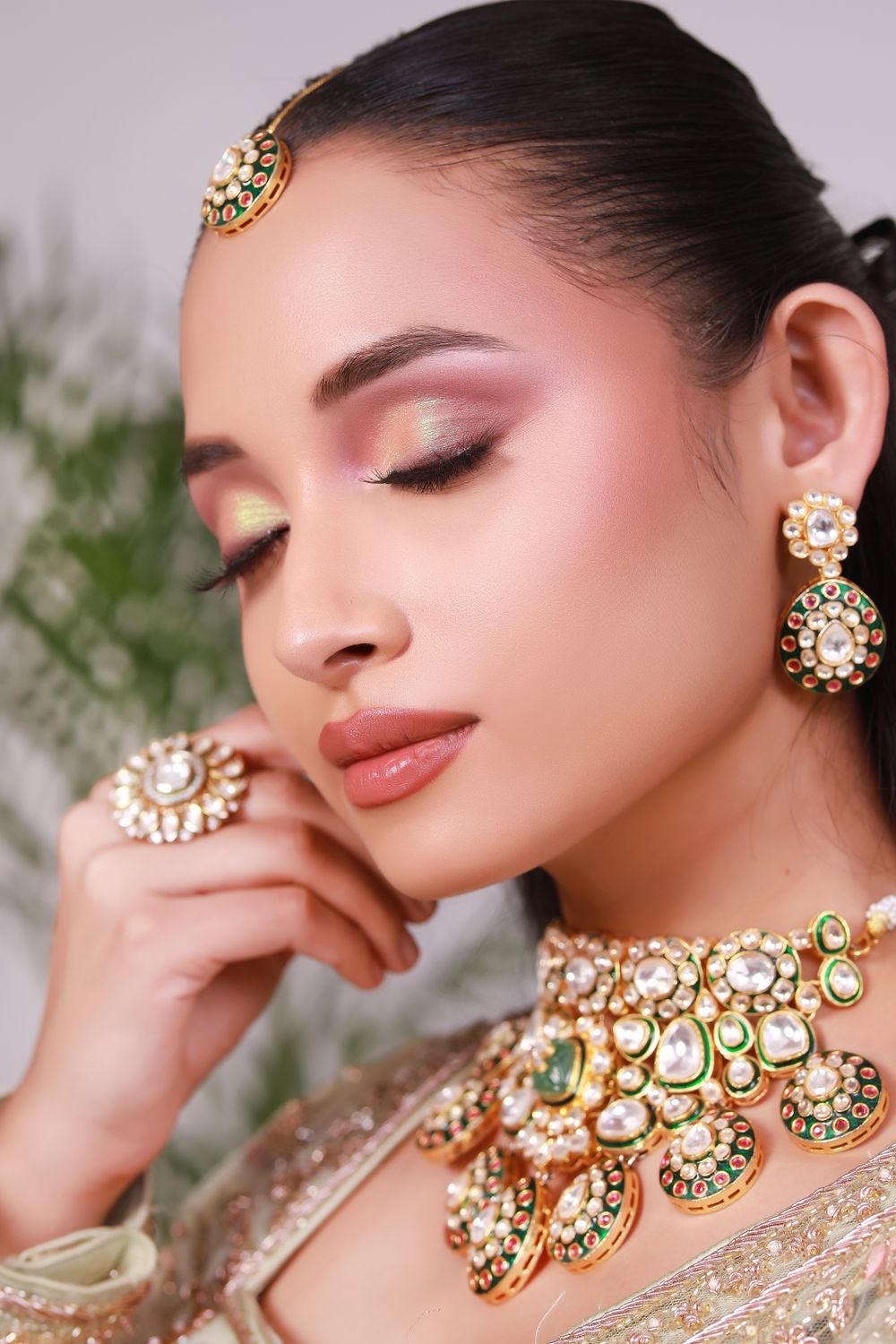 Woman with soft pink eye makeup wearing gold kundan jewellery