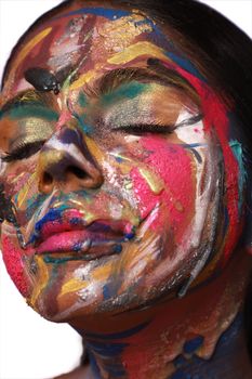 Close-up portrait of a face with vibrant, abstract paint splattered creatively.