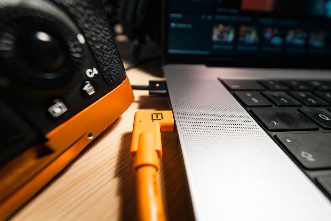 Close-up of Camera Tethered to Laptop with Orange Cable · Free Stock Photo