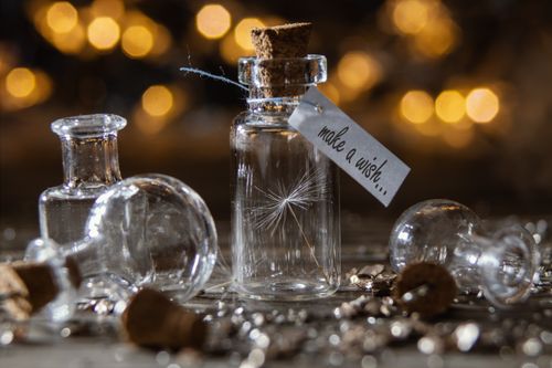 Free Glass wish bottles with corks and warm bokeh lights; magical and serene atmosphere. Stock Photo