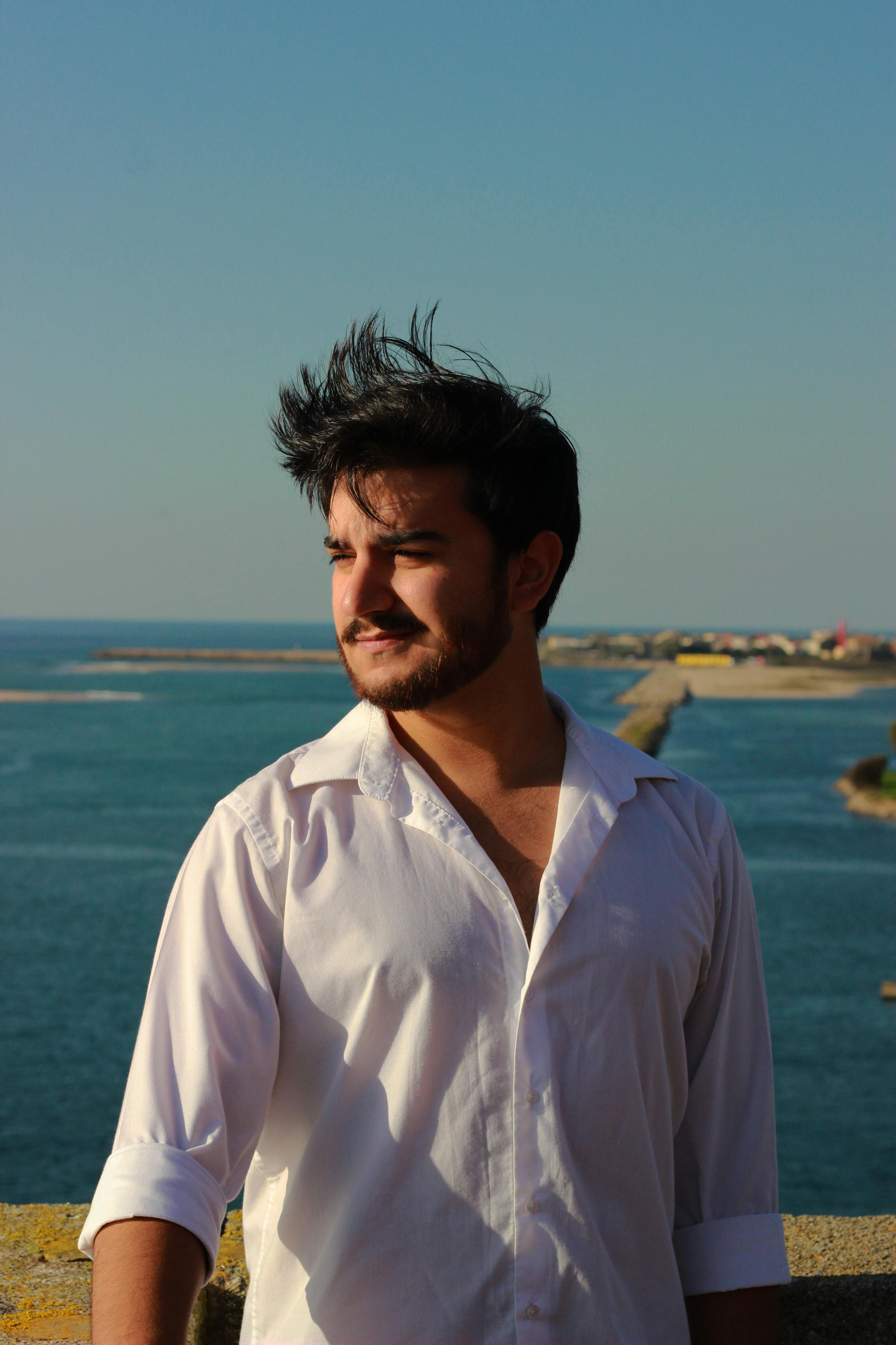 Man with windswept hair standing by the sea in Esposende, Portugal.