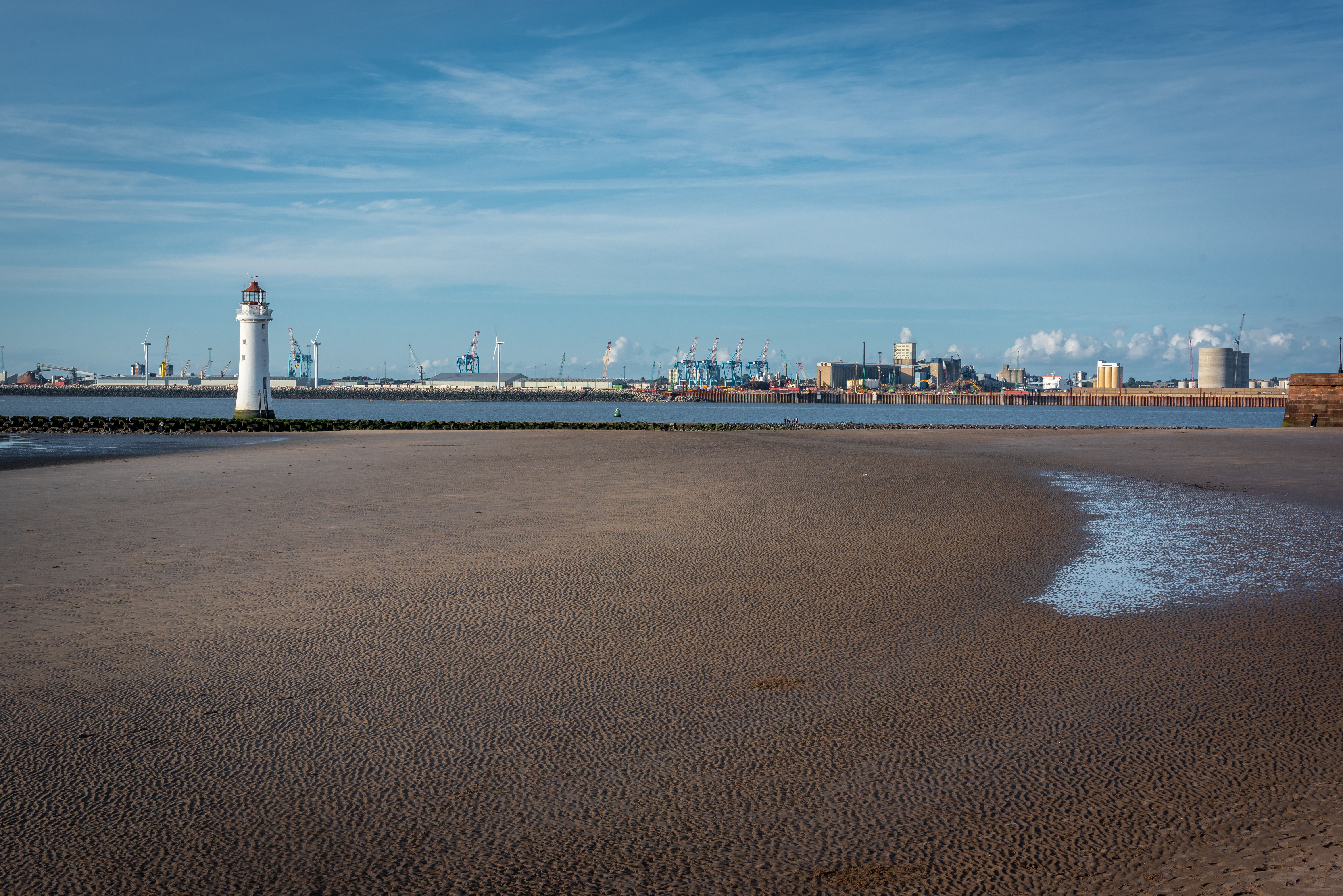 New Brighton Lighthouse with coastal scenery and blue sky in England, UK.