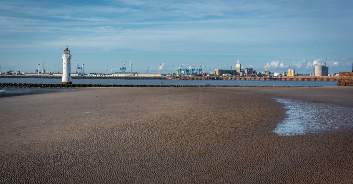 New Brighton Lighthouse with coastal scenery and blue sky in England, UK.
