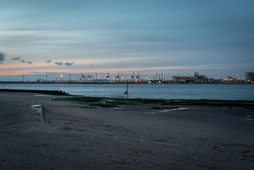 Free A serene view of New Brighton Beach with the shipyard at dusk, captured in England. Stock Photo