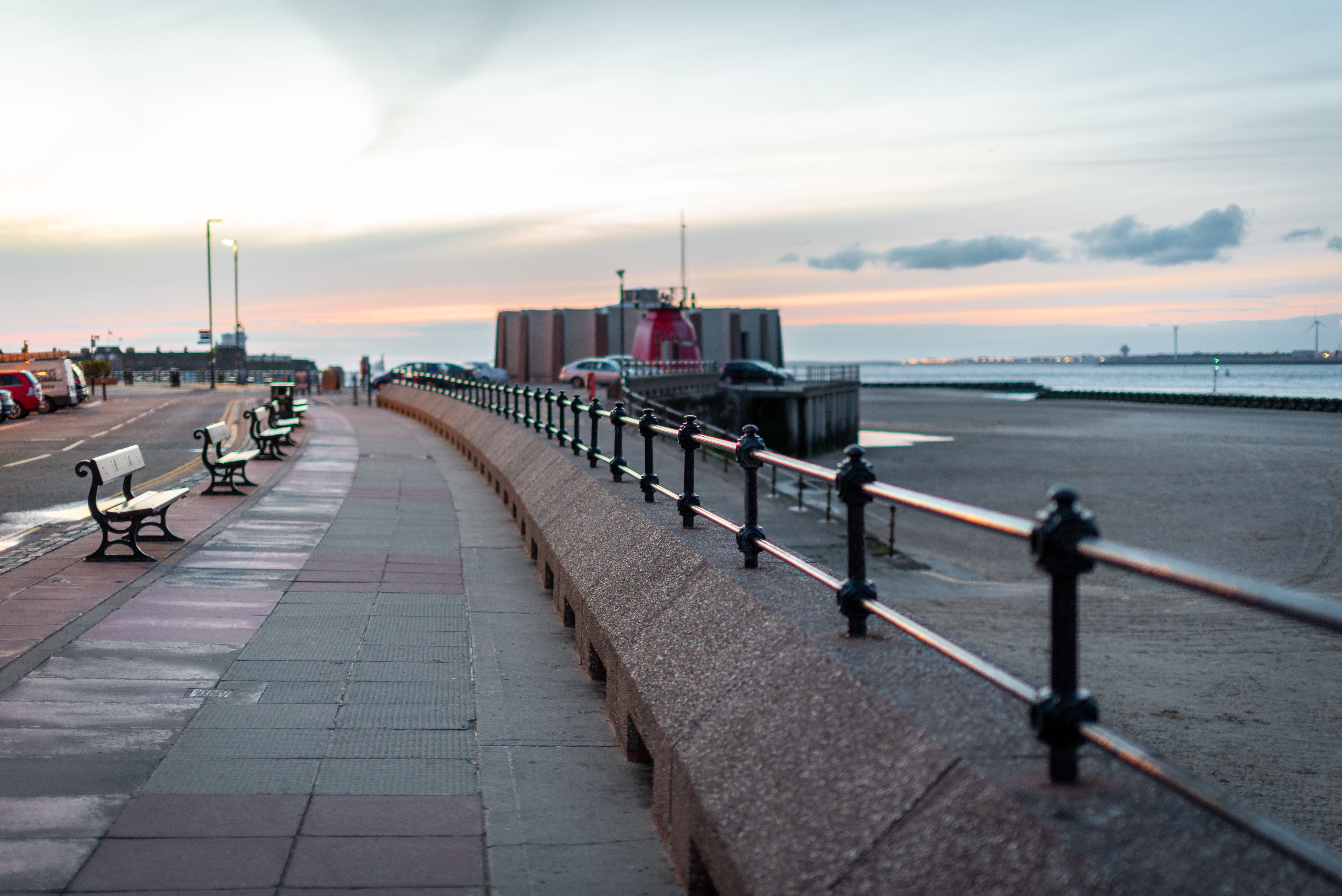 Sunset view of the promenade and beach at Wallasey, featuring a calm seaside atmosphere.