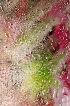Vibrant abstract photo with colorful hues and water droplets on glass, creating a unique texture.