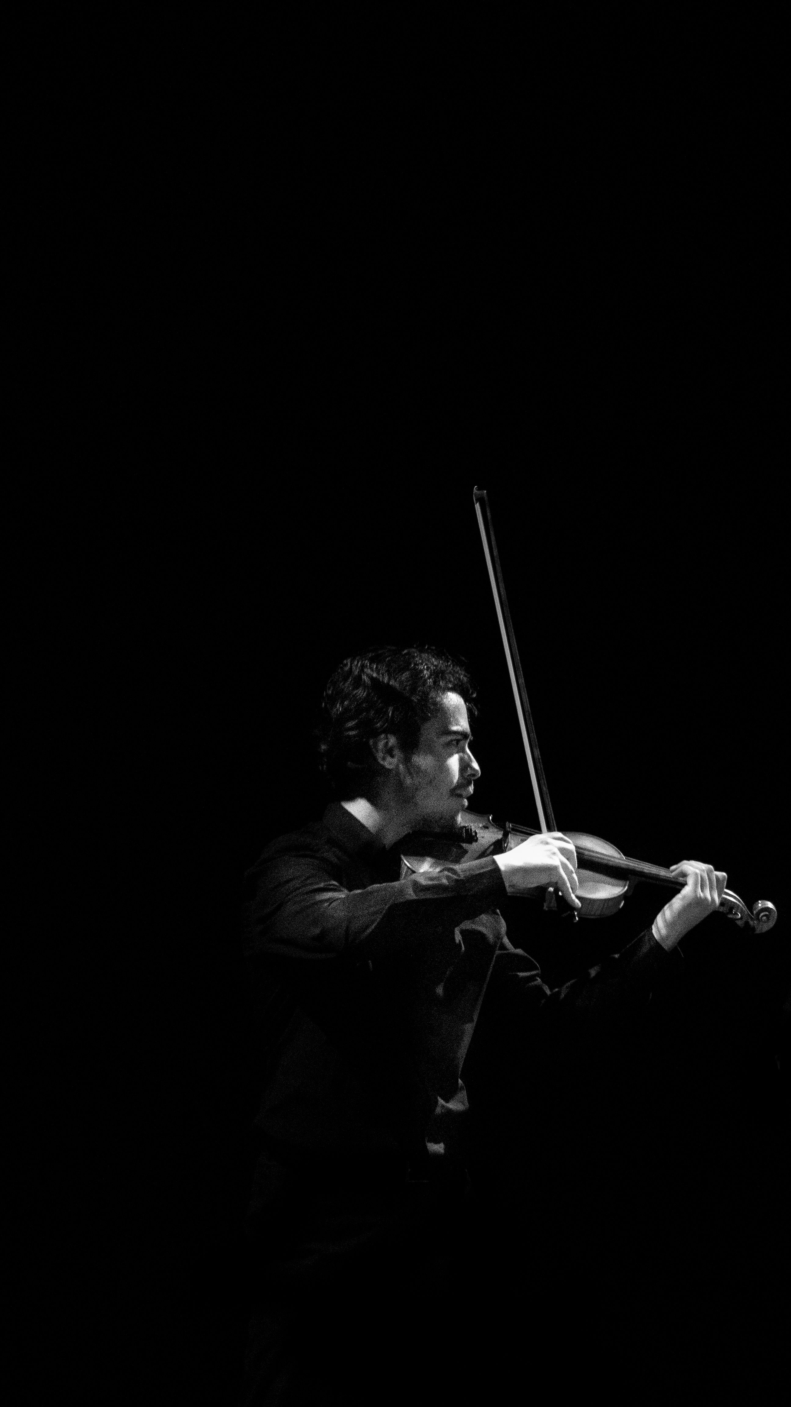 Black and white photo of a violinist playing passionately in Rabat, Morocco.