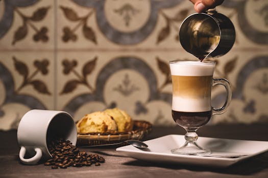 特写镜头中，一杯分层咖啡饮料在舒适的环境里被倒入咖啡豆和饼干