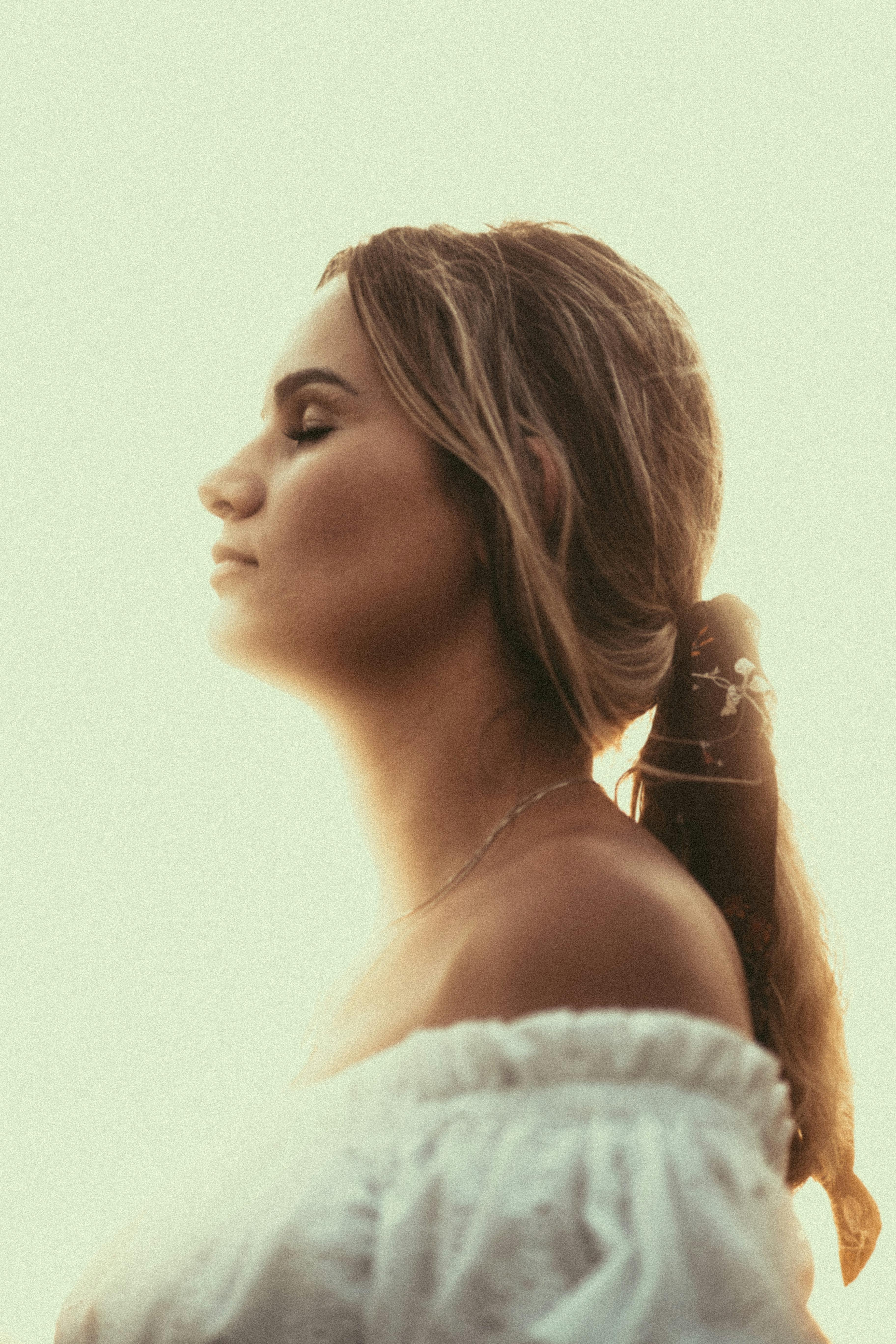 温暖的阳光照亮了一个女人闭着眼睛的平静侧影