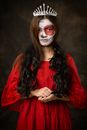 女人在万圣节打扮成令人毛骨悚然的女王头骨造型，化了妆并戴了皇冠