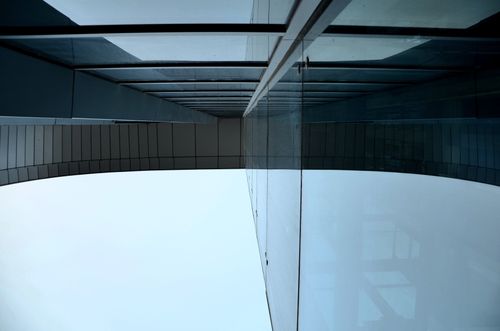 Free Abstract view of modern architecture with glass and metal elements reflecting a unique angle. Stock Photo