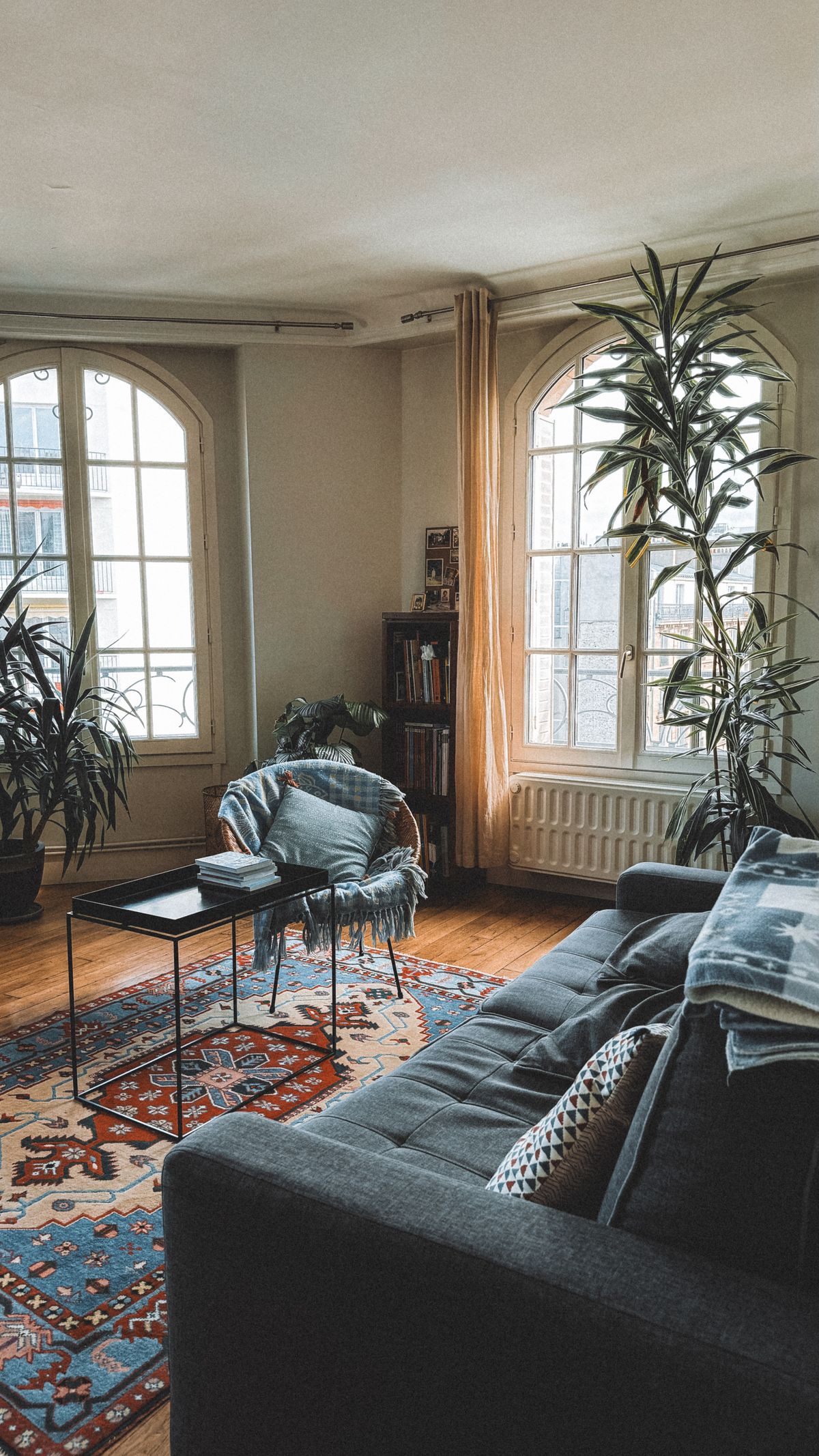 Cozy modern living room with wooden furniture, shelving, rug and soft lighting