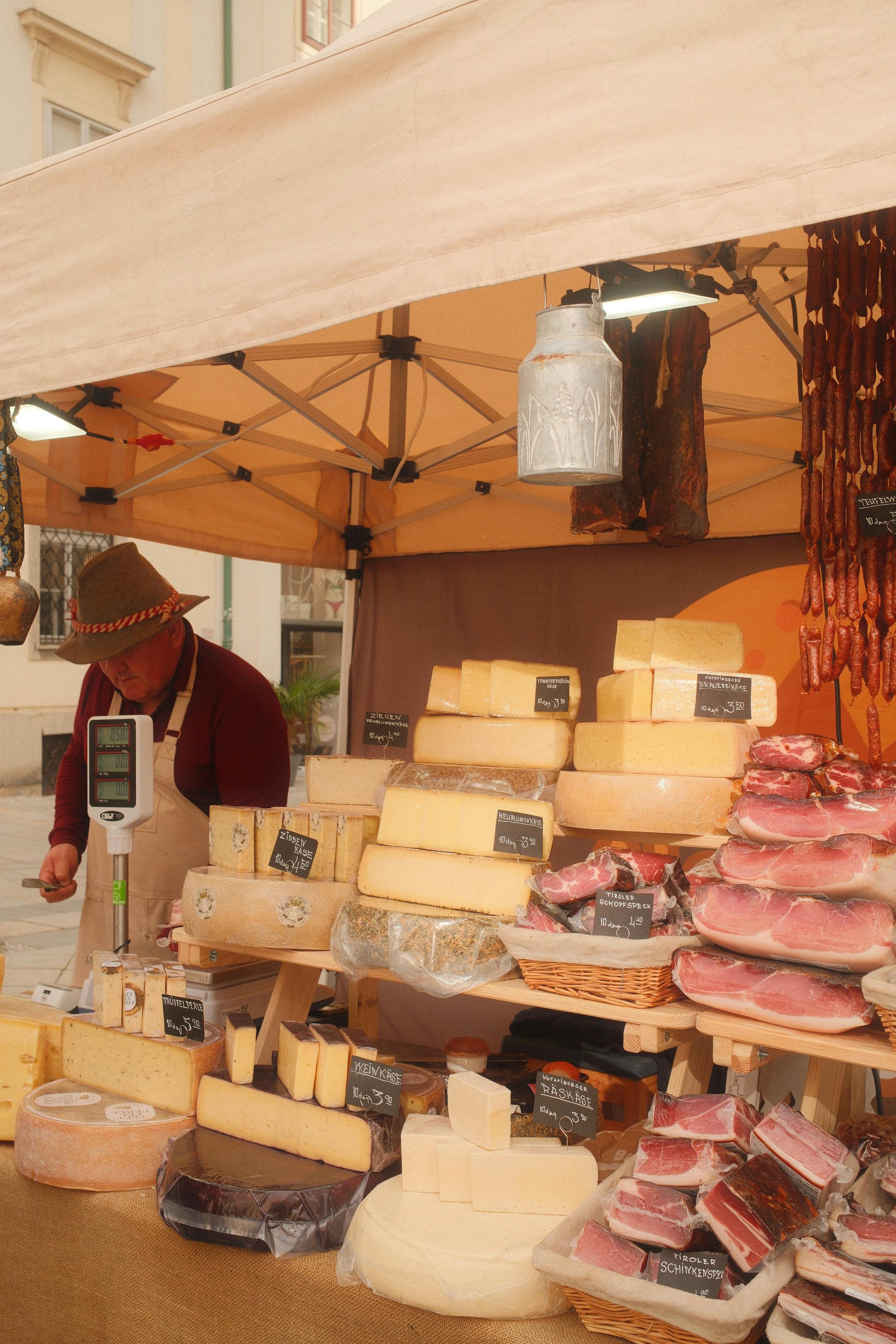 Stand de marché avec fromages et charcuteries traditionnelles, exposition de produits artisanaux
