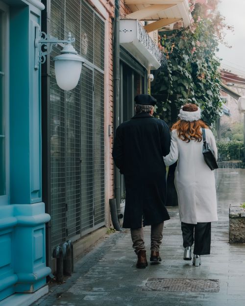 Free Couple walking hand in hand on a charming İstanbul street, showcasing winter fashion and love. Stock Photo