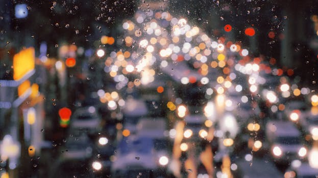 Blurry city lights create a stunning bokeh effect on a rainy night in Hanoi, Vietnam.