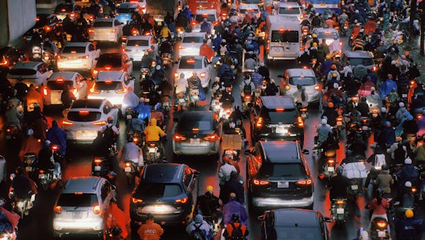 Traffic congestion in Hanoi with cars and motorbikes after rain, showcasing urban hustle.