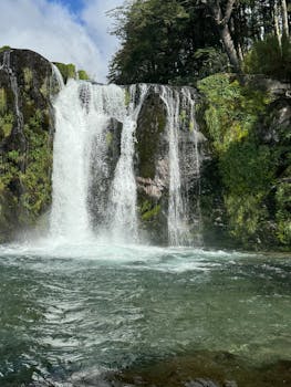 Lush greenery and cascading waterfall in Villa La Angostura, a natural paradise in Argentina.