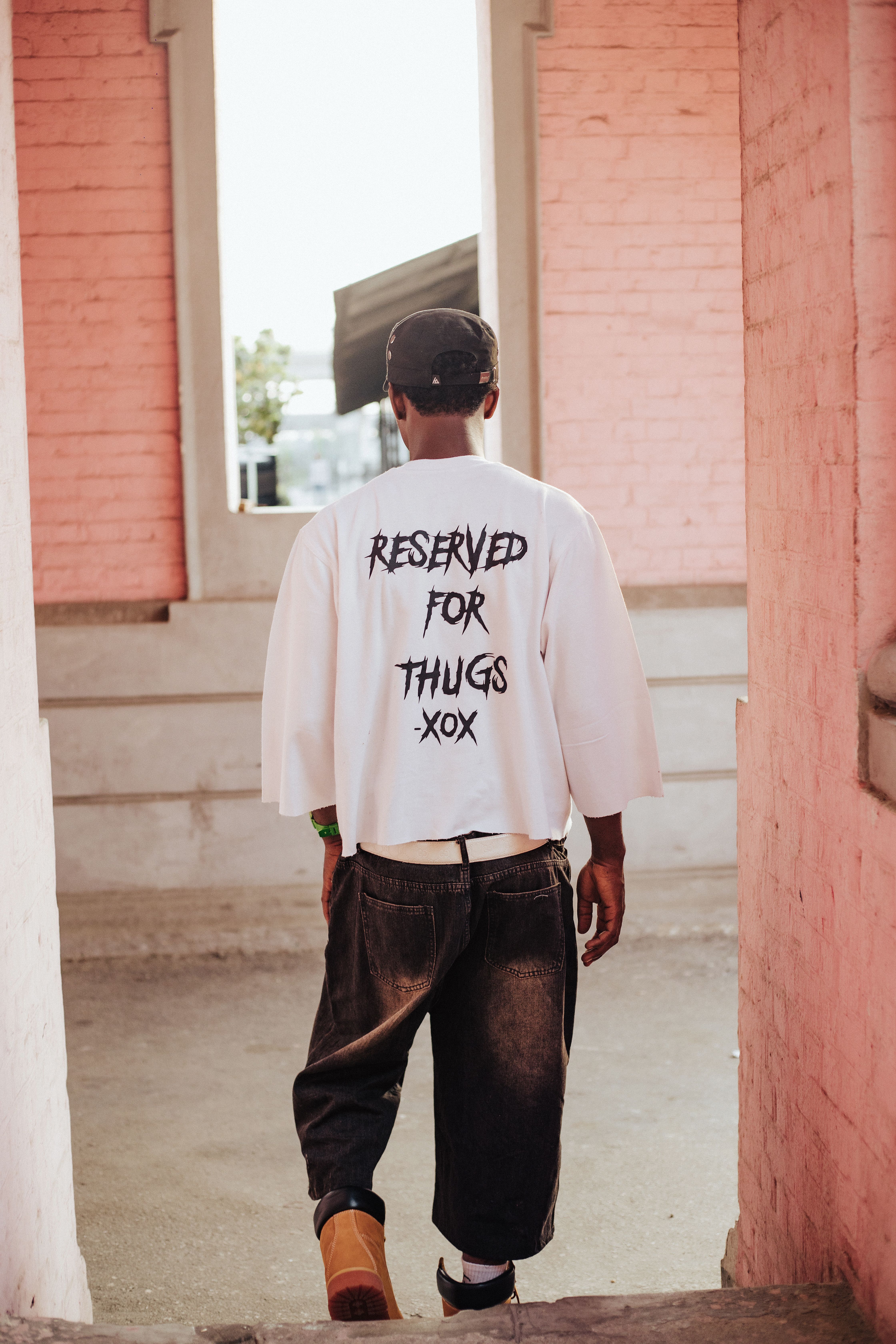 Back view of a young man in urban fashion with a bold statement shirt.