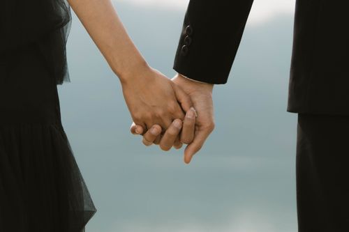 Free A close-up of a couple holding hands, capturing a romantic moment in Indonesia. Stock Photo