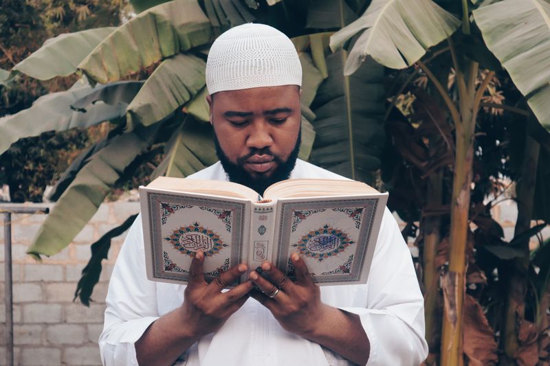 Man reading the Quran outdoors — Daily Supplications