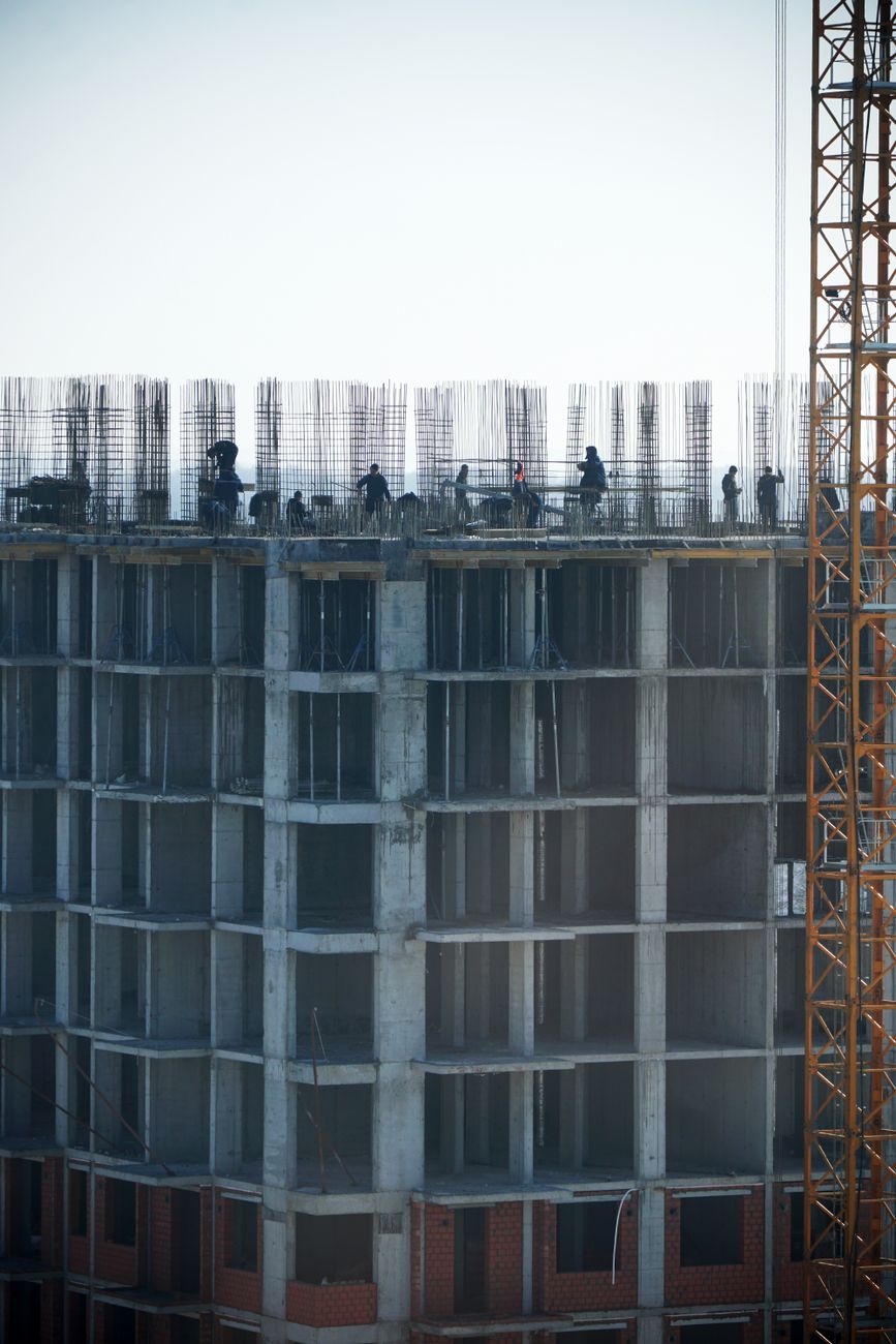 Construction workers building a high-rise, showcasing urban development.