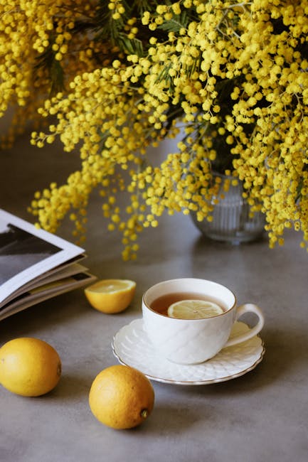 A steaming cup of Corsican Lemon Tea with fresh lemons and Corsican landscape in the background