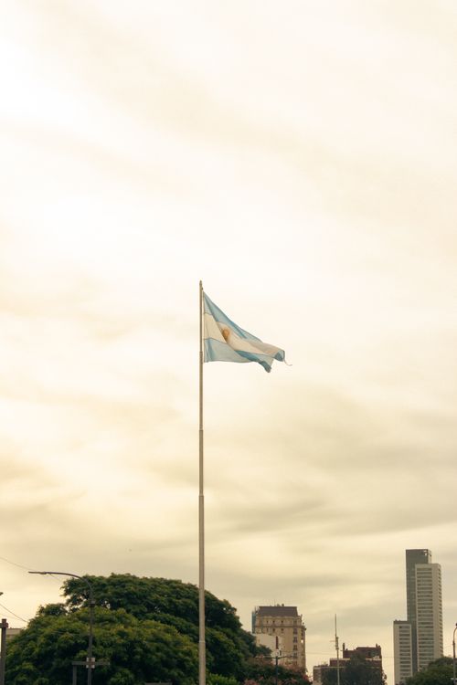 Free Photograph of the Argentinian flag waving against Buenos Aires city skyline. Stock Photo