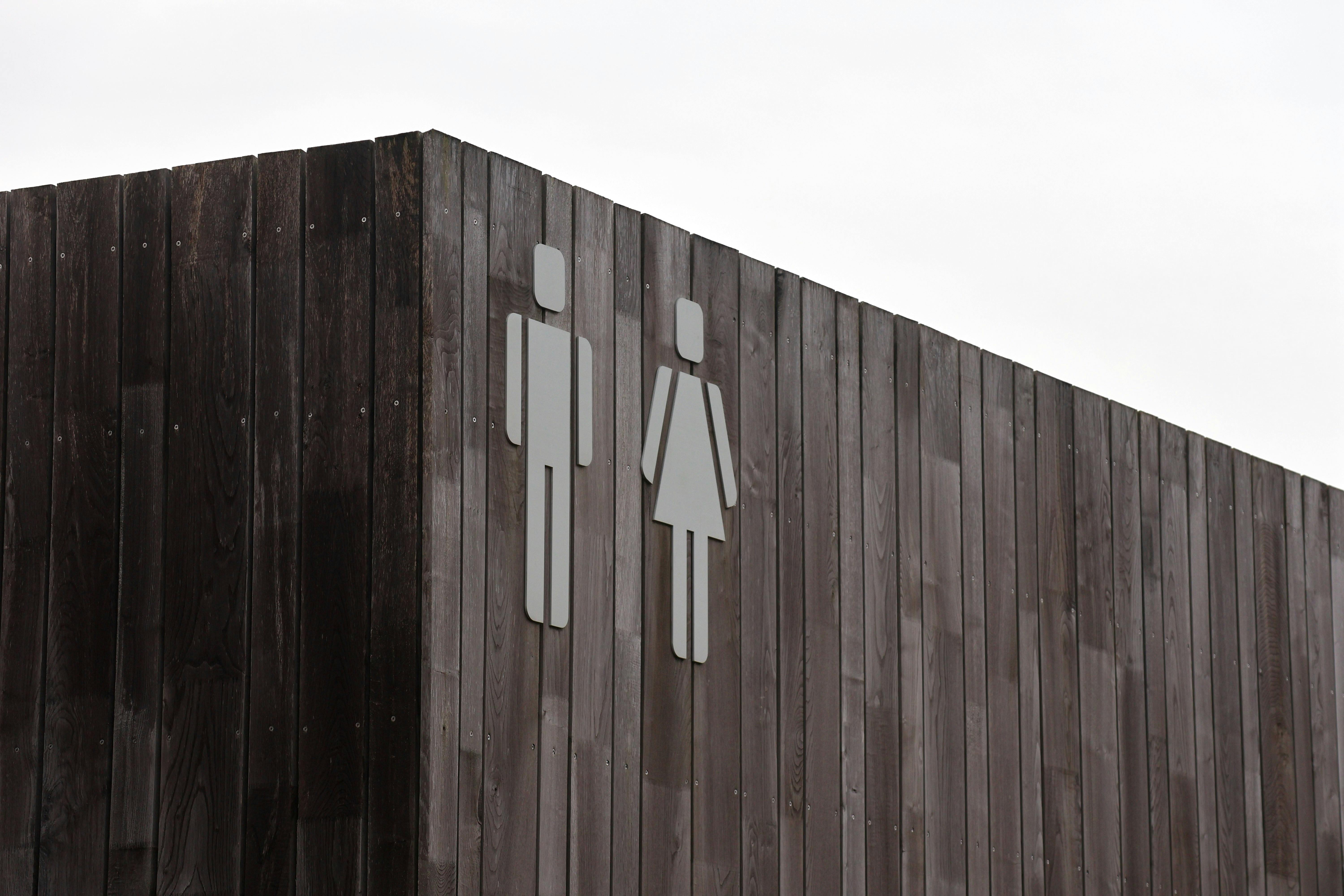 Free Exterior of a modern wooden restroom with male and female icons. Stock Photo