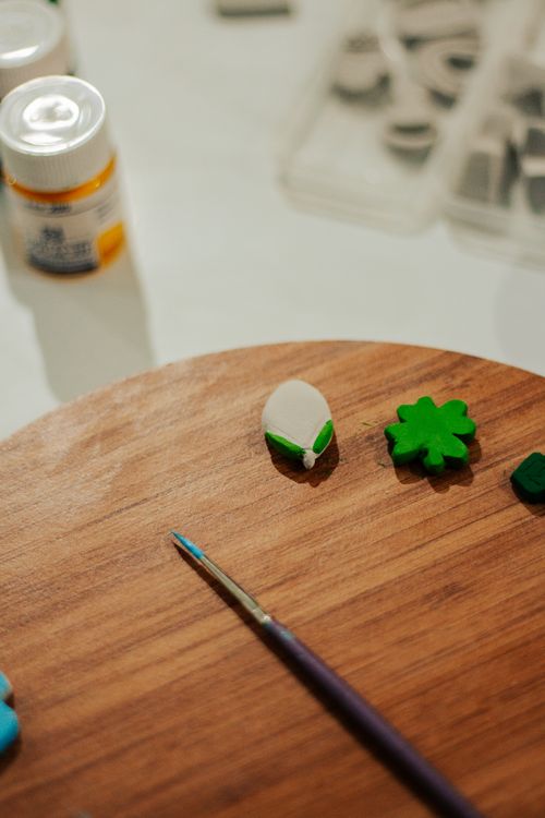 Free Close-up of art supplies, including a paintbrush and clay shapes, on a wooden surface. Stock Photo