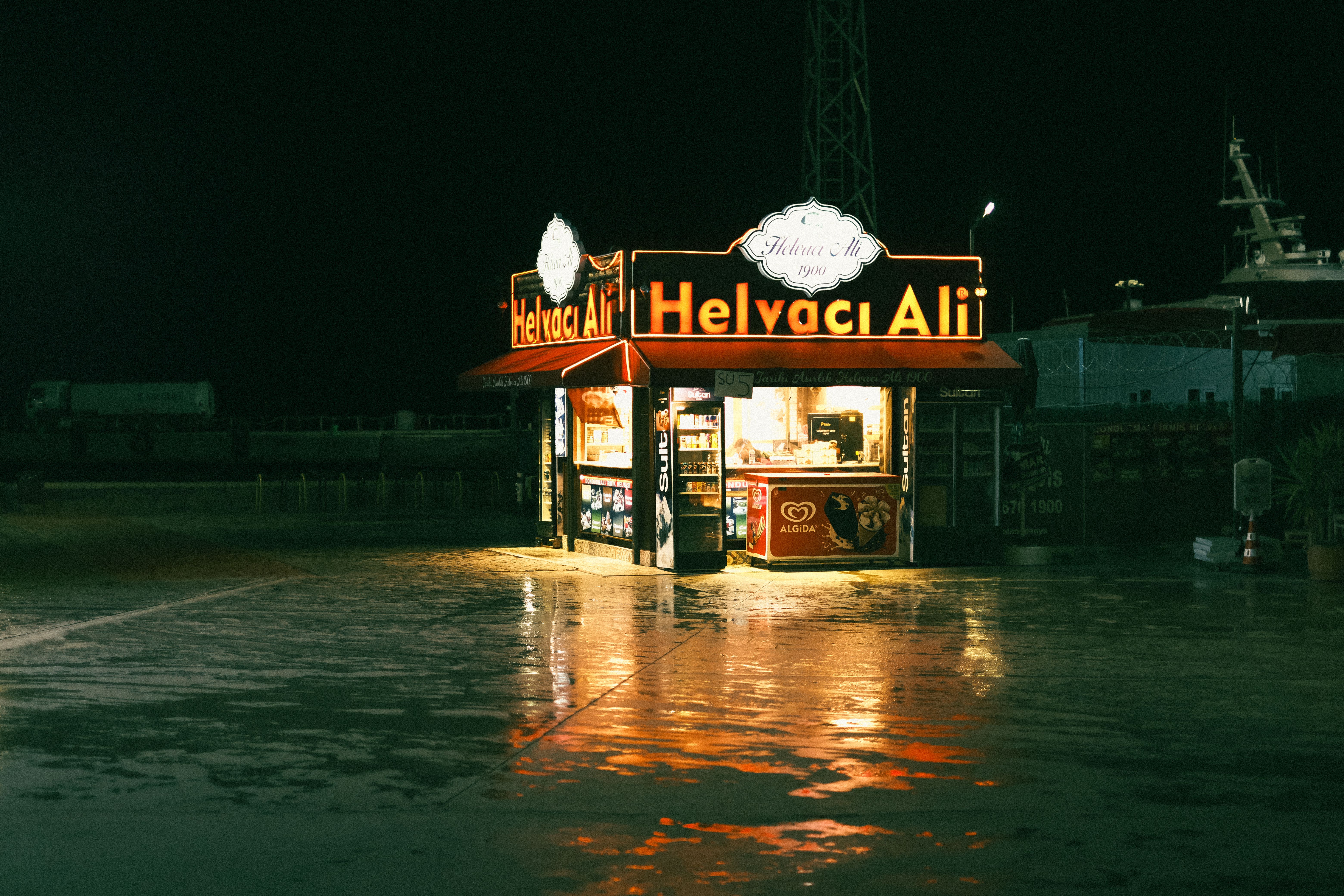 Illuminated Night Street Food Kiosk Reflecting on Wet Street · Free ...
