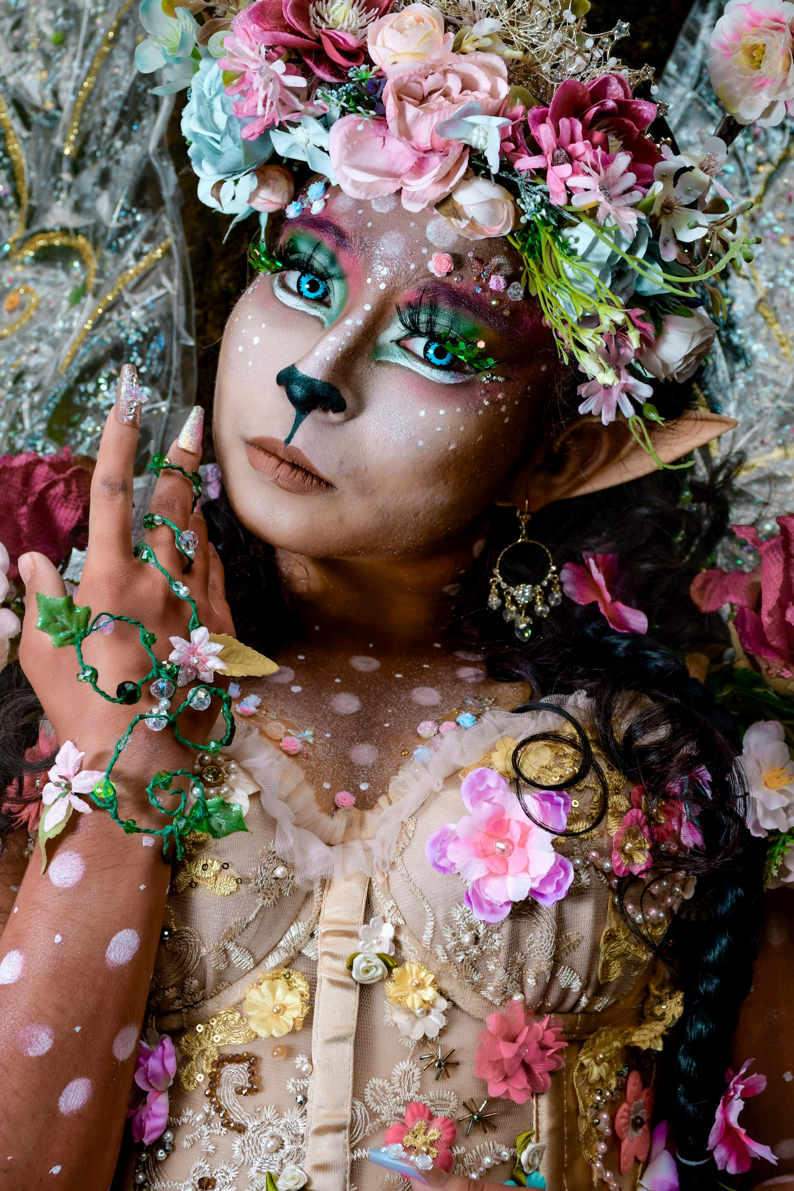 A fantastical portrait featuring elaborate floral costume and fantasy makeup.