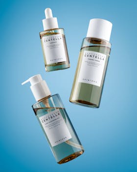 Skincare products including serum, toner, and cleansing gel on a blue background.