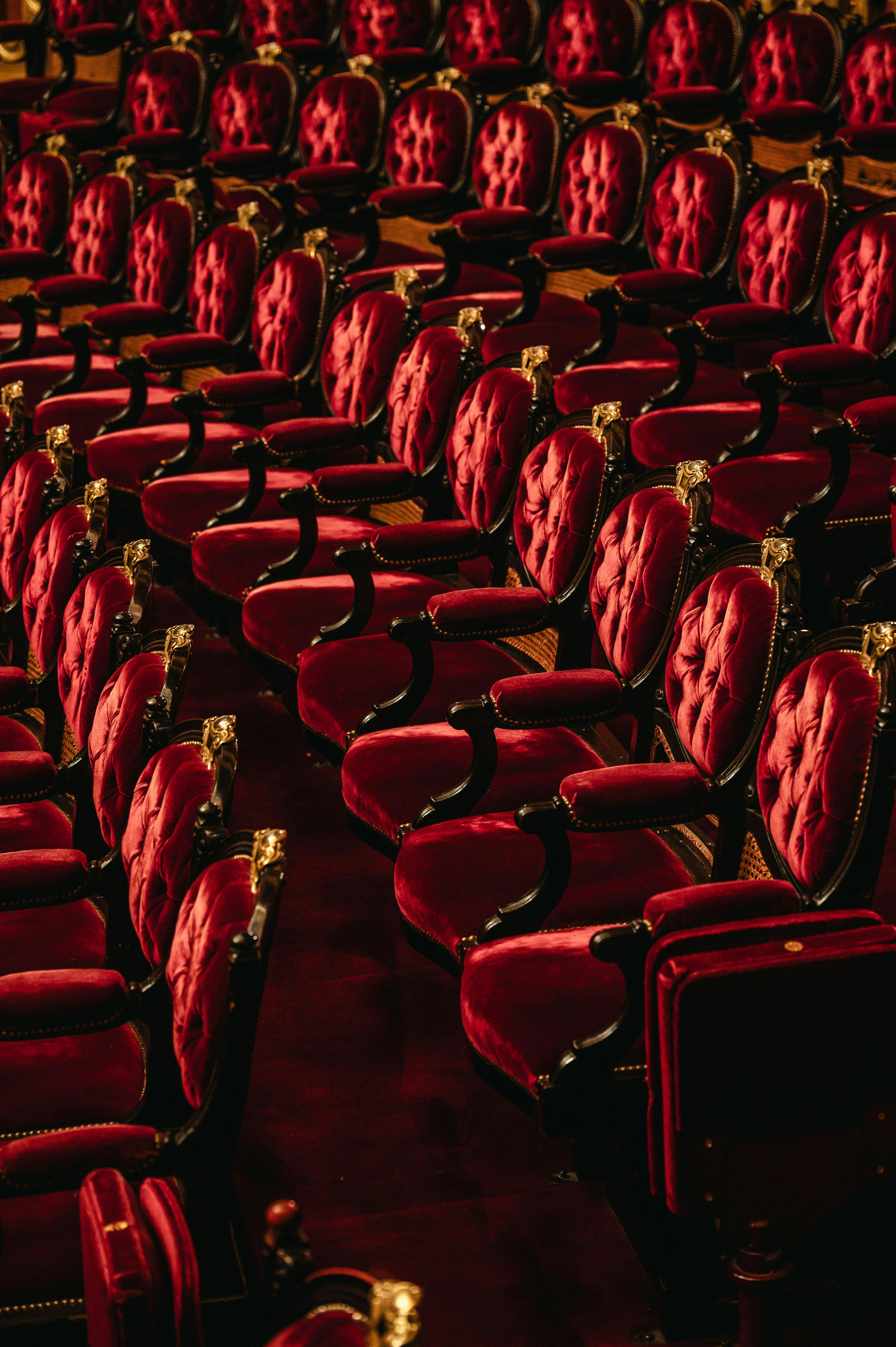Gratis Eleganti poltrone in velluto rosso in un sontuoso ambiente da teatro dell'opera, che trasuda lusso classico. Foto a disposizione