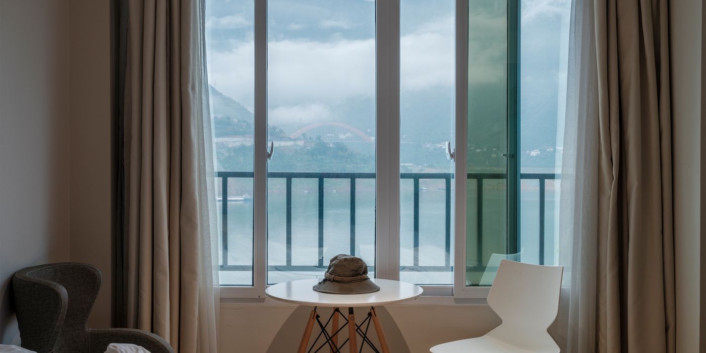 A cozy hotel room with a large window and a mountain view