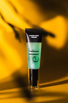 Close-up of E.l.f. Power Grip Primer on a vibrant yellow background, highlighting its sleek design.
