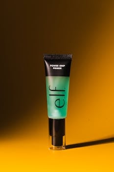 Close-up of e.l.f. Power Grip Primer with dramatic studio lighting on a yellow background.
