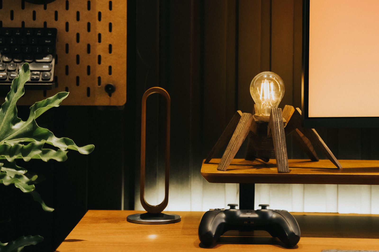 Modern desk setup with a gaming controller, technology accessories and ambient lighting