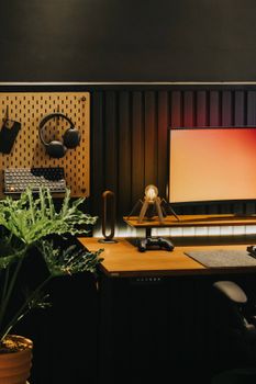 Stylish desk setup featuring gaming gear and greenery for productivity.