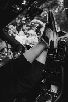 Monochrome shot of person resting feet on car dashboard, casual and laid-back vibe