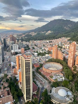 Aerial view of Bogotá featuring Torre Colpatria and the iconic bullring at sunset.